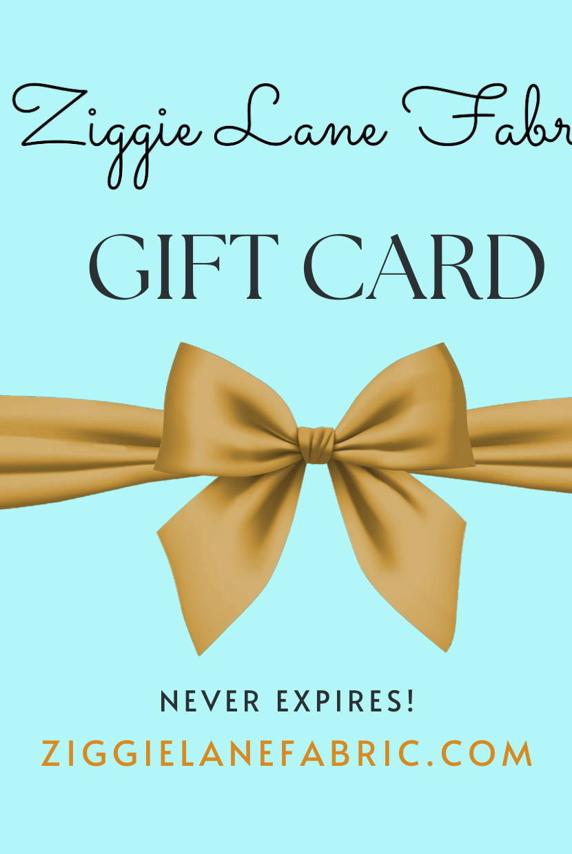Pretty blue gift card that says Ziggie Land Fabric Gift Card Never Expires with gold bow